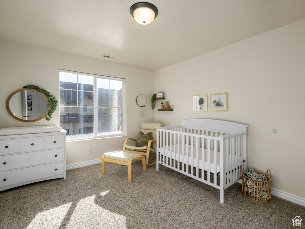 Bedroom featuring a nursery area, carpet, visible vents, and baseboards