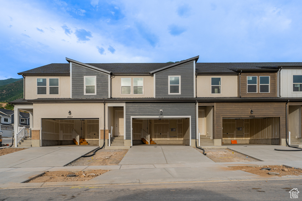 Townhome / multi-family property featuring a garage and driveway
