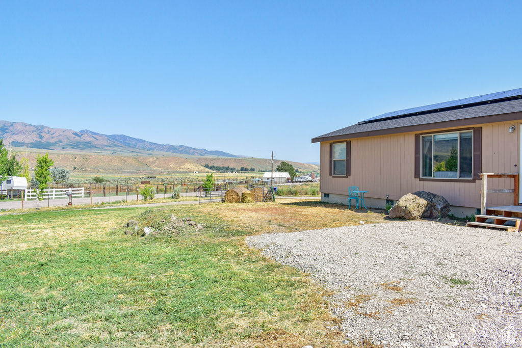 View of yard with a mountain view, a rural view, and fence