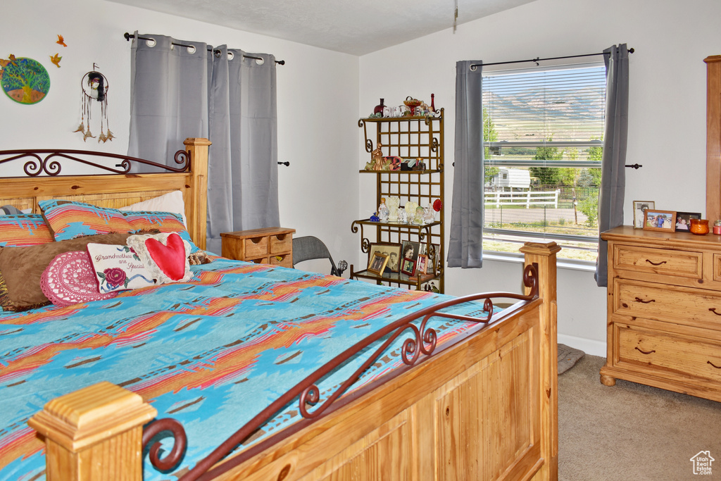 Bedroom featuring light carpet and vaulted ceiling