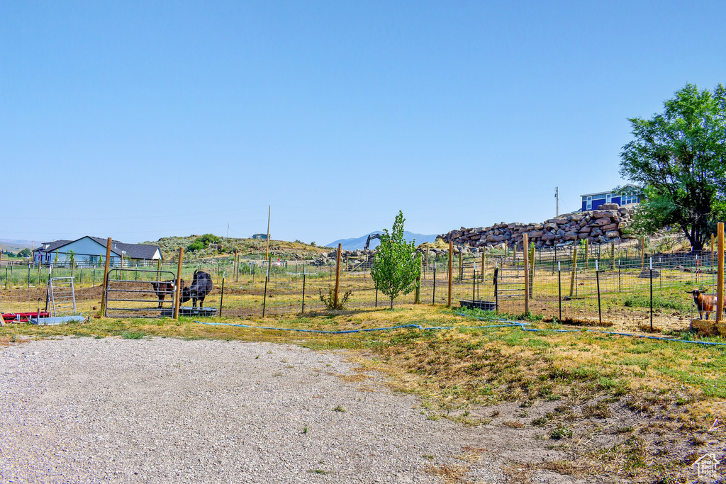 Exterior space featuring a rural view, a mountain view, a vegetable garden, and fence