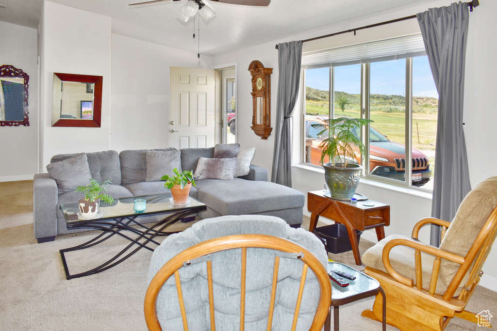 Carpeted living room featuring baseboards and ceiling fan