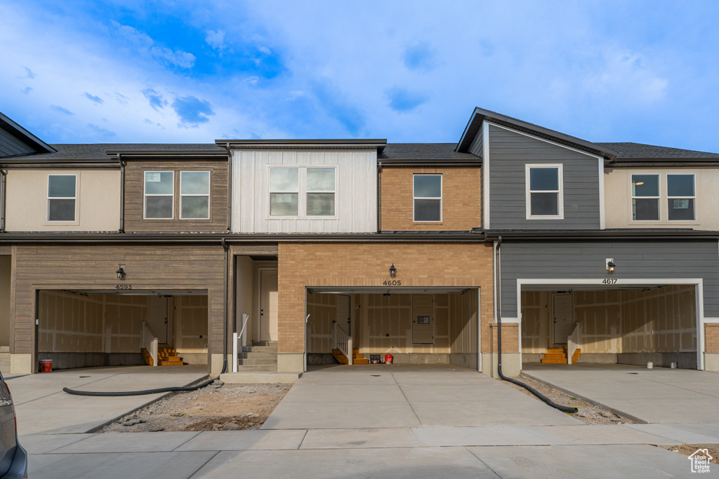 Townhome / multi-family property featuring driveway and a garage