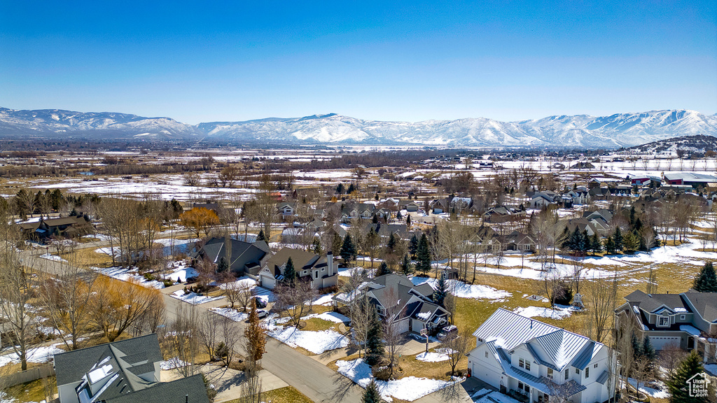 Snowy aerial view with a mountain view and a residential view