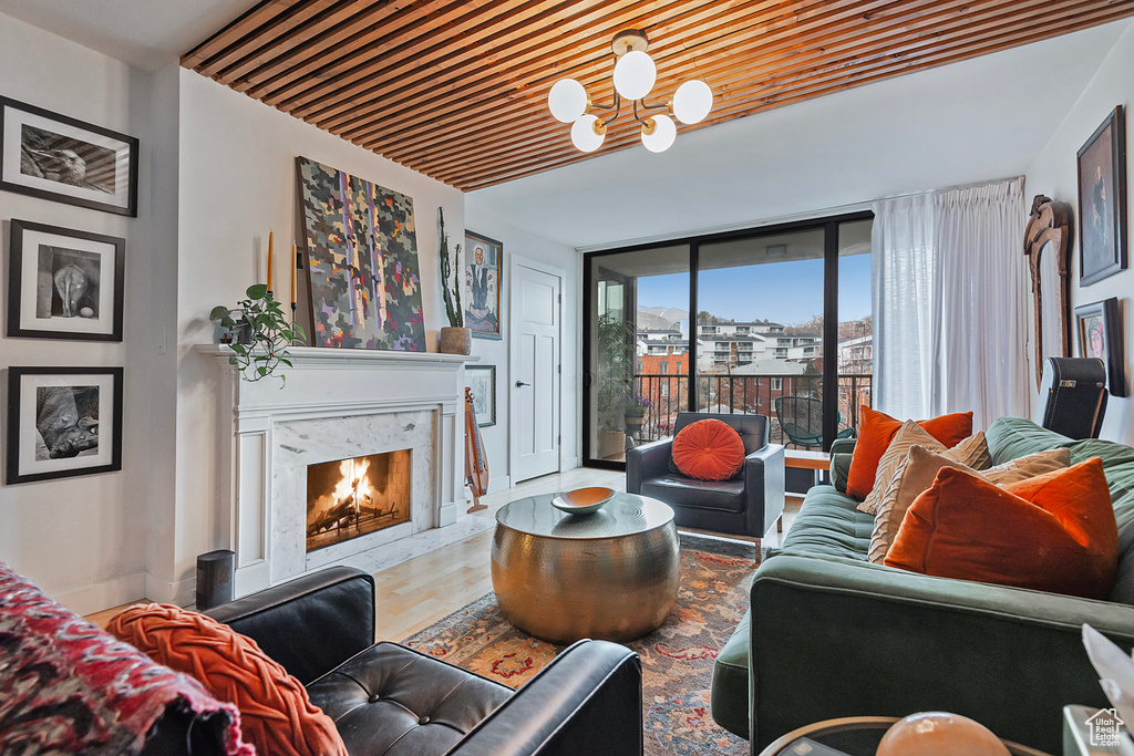 Living room with baseboards, an inviting chandelier, wood finished floors, and a fireplace