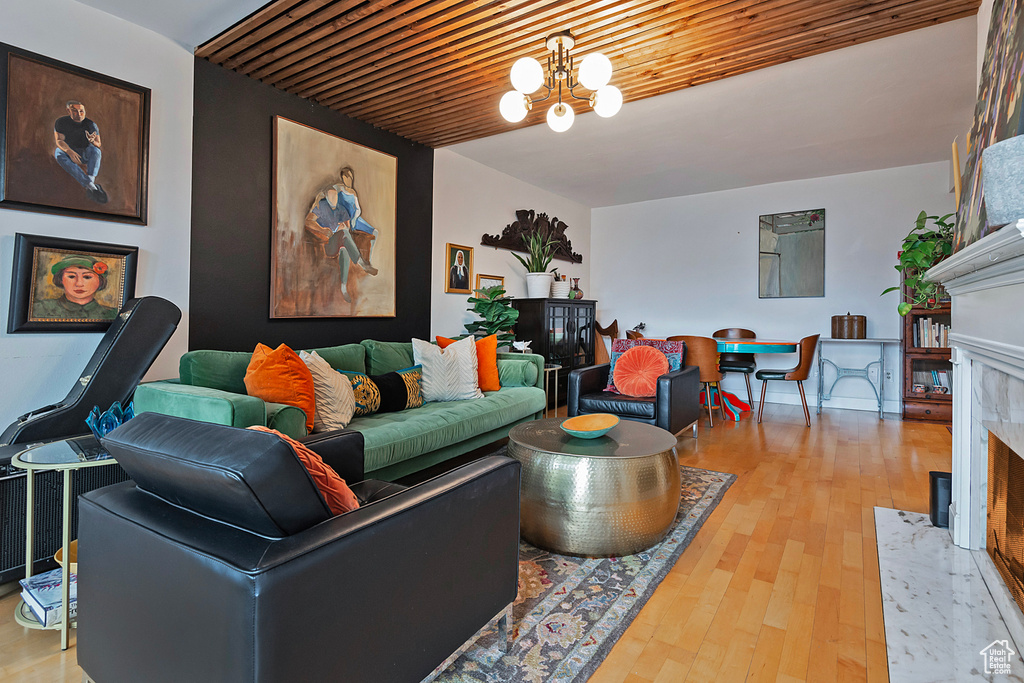 Living area with a premium fireplace, wood finished floors, and a chandelier