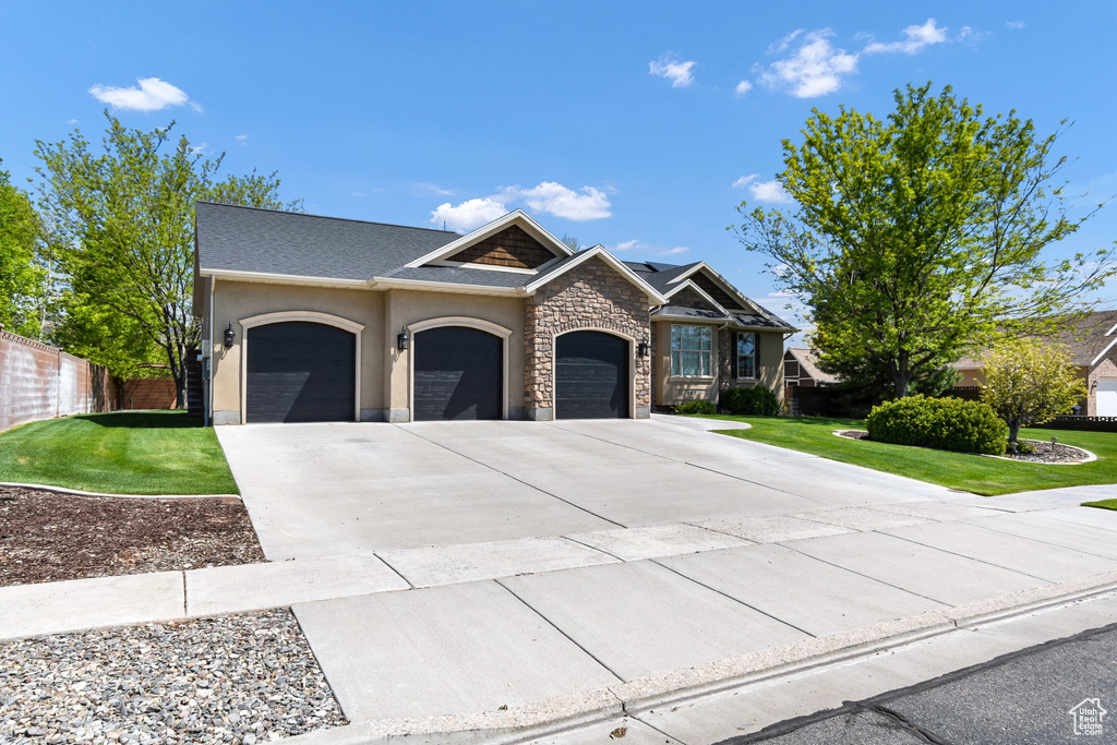 Craftsman-style house with an attached garage, concrete driveway, stucco siding, and stone siding
