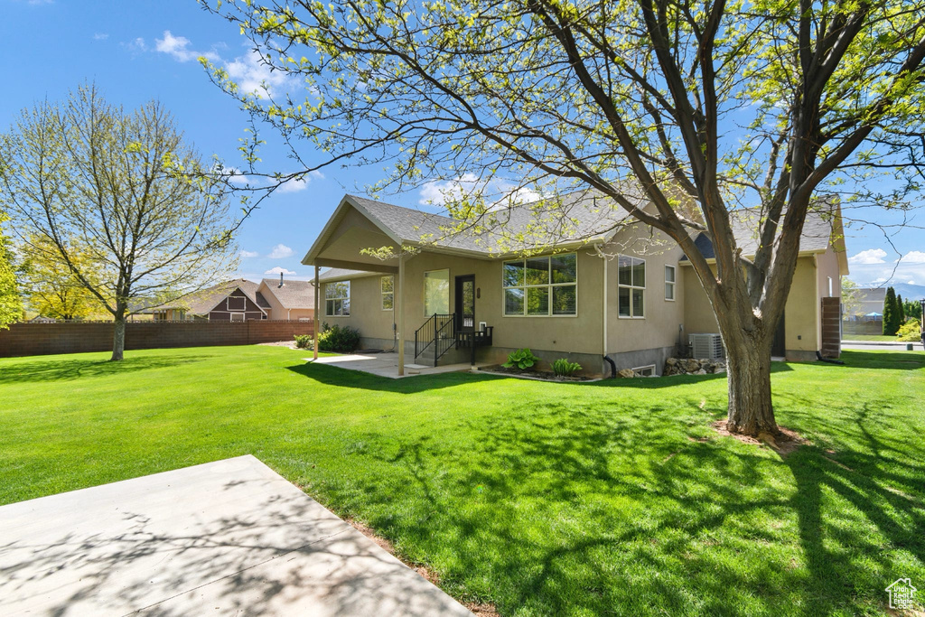 View of front of house featuring a patio area, roof with shingles, and stucco siding