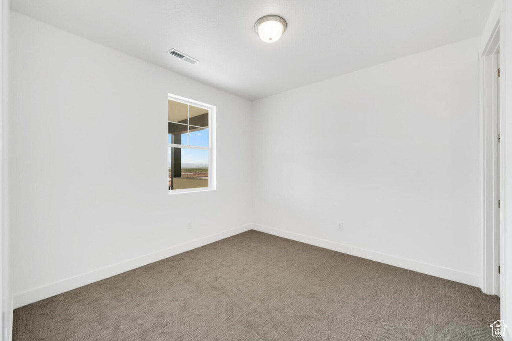 Unfurnished room featuring visible vents, baseboards, and carpet flooring