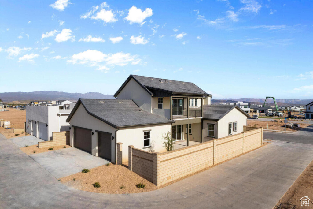 View of front facade featuring a fenced front yard, a garage, driveway, and stucco siding