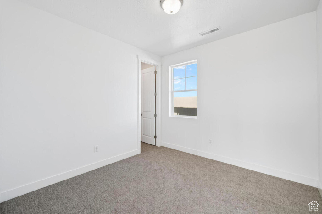 Spare room with visible vents, carpet flooring, and baseboards