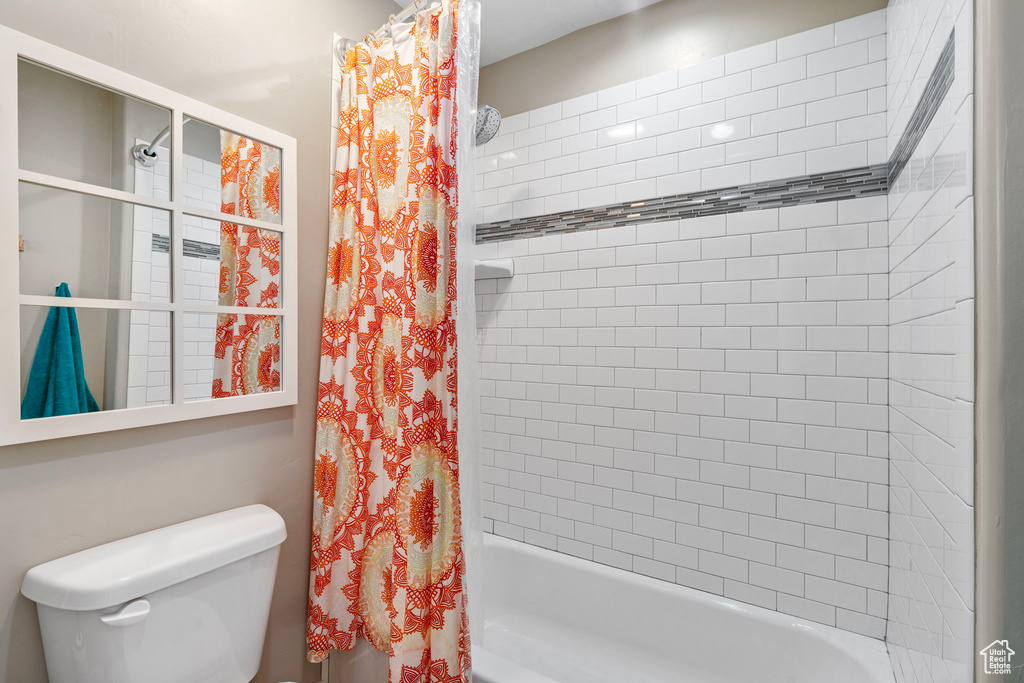 Bathroom with shower / tub combo and toilet