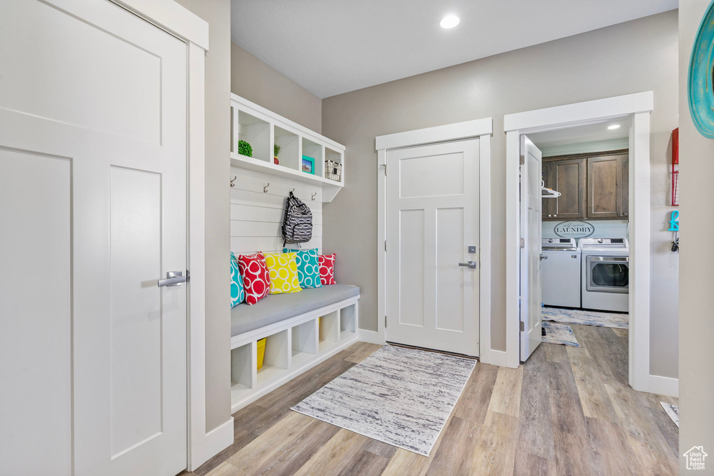 Mudroom featuring recessed lighting, light wood-type flooring, baseboards, and washer and clothes dryer