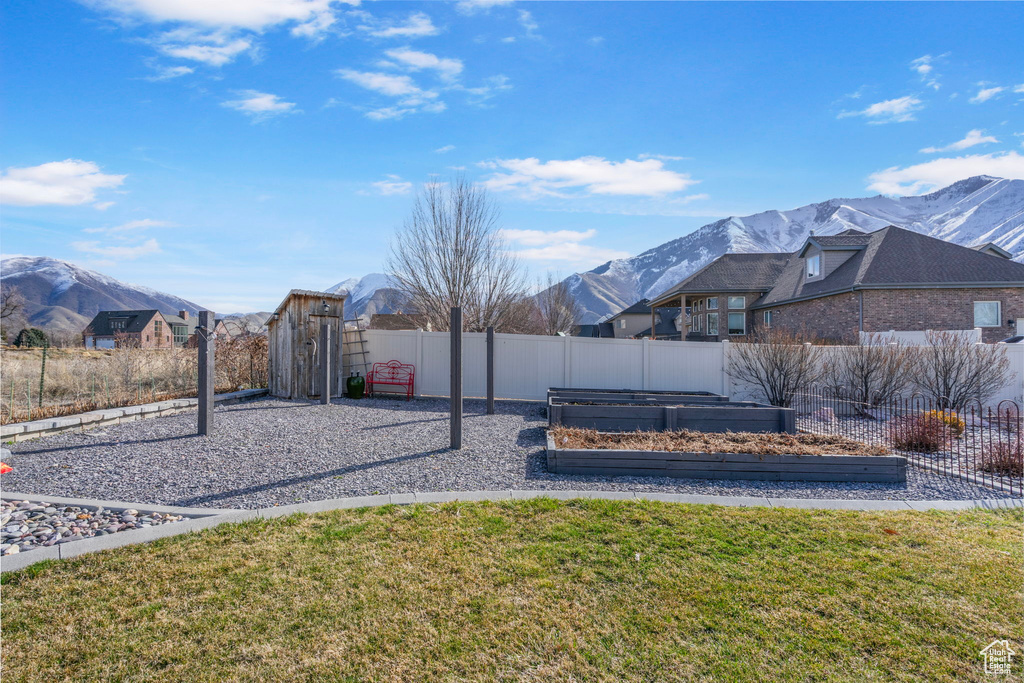 View of yard featuring a mountain view, fence, and a garden