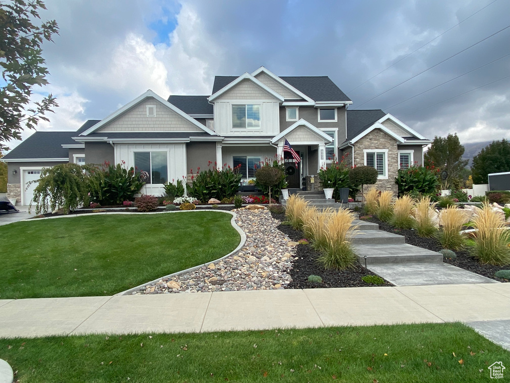 Craftsman house featuring a front yard and stone siding