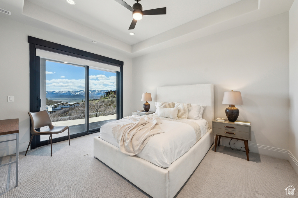 Bedroom with recessed lighting, a tray ceiling, access to exterior, and carpet