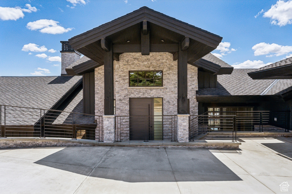 Property entrance featuring a shingled roof