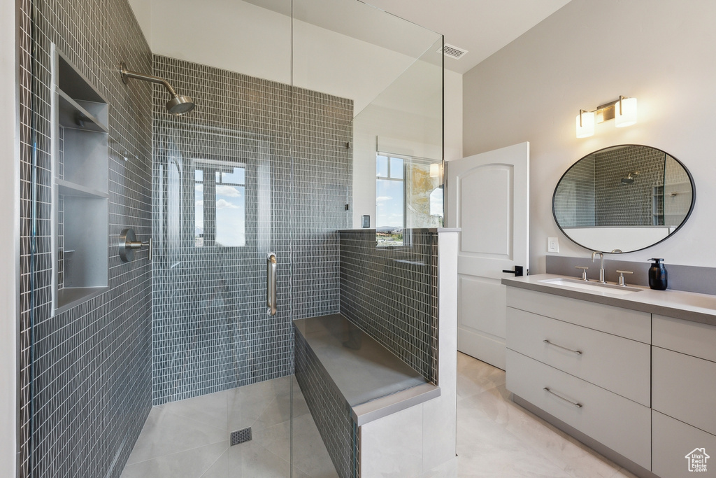 Full bathroom with vanity, a shower stall, and tile patterned floors