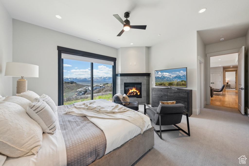 Bedroom with ceiling fan, a tile fireplace, baseboards, light carpet, and recessed lighting