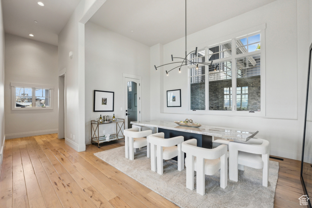 Dining space featuring plenty of natural light, a high ceiling, and light wood-type flooring