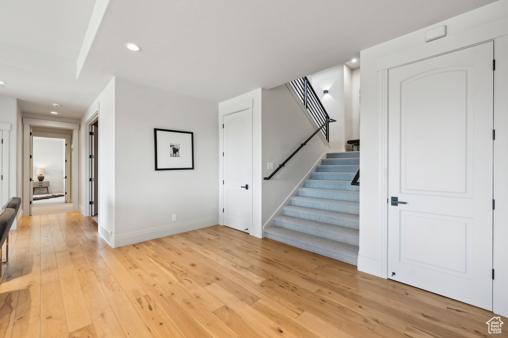 Stairs featuring wood-type flooring, recessed lighting, and baseboards