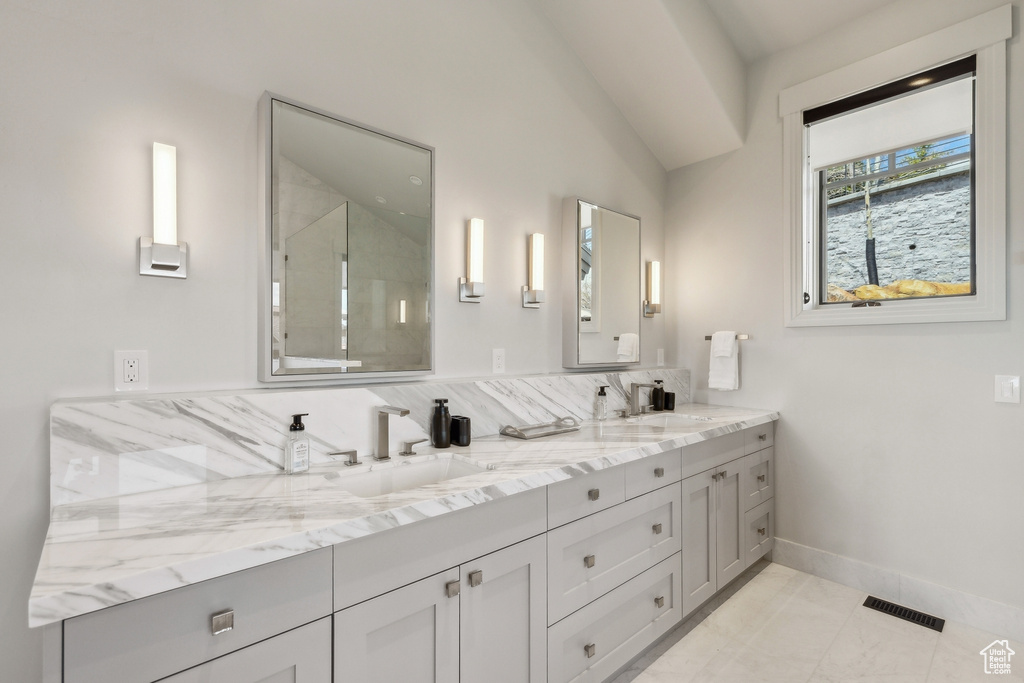 Bathroom featuring a sink, walk in shower, double vanity, and visible vents