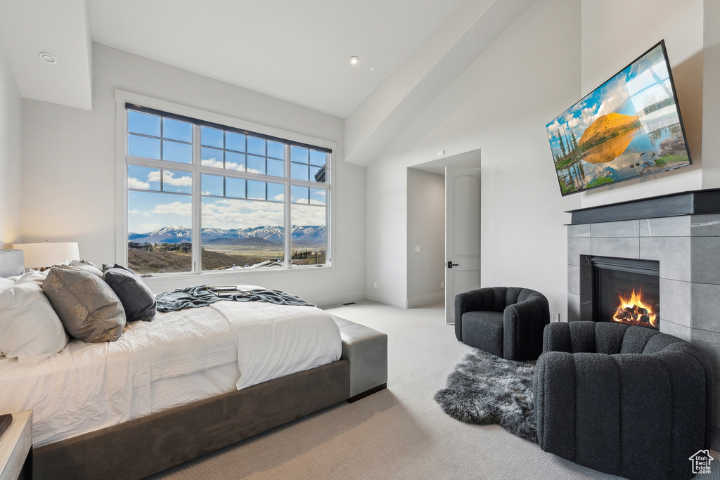 Bedroom featuring carpet flooring and a tiled fireplace