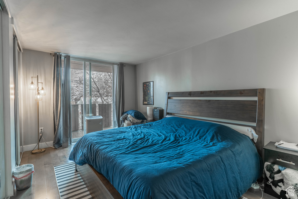Bedroom featuring access to exterior, wood finished floors, and baseboards
