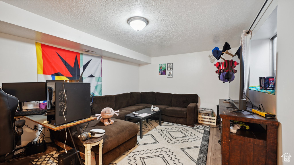 Living area with visible vents, a textured ceiling, and wood finished floors