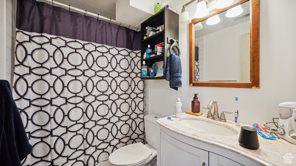 Full bath with toilet, vanity, and a shower with curtain