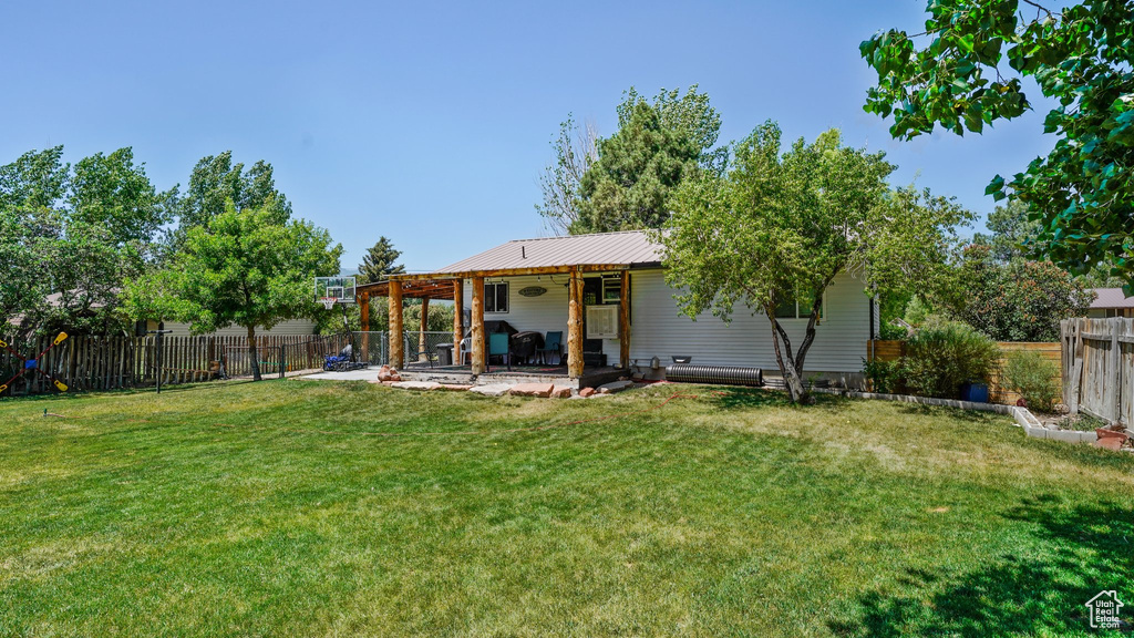 Rear view of property with a fenced backyard and a patio area