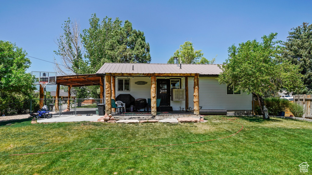 View of front of house with a fenced backyard, a patio area, and a metal roof