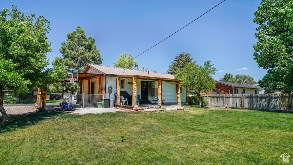 Rear view of house with a fenced backyard, a patio area, and a metal roof