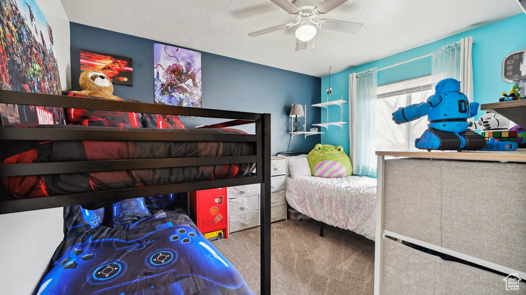 Carpeted bedroom featuring ceiling fan