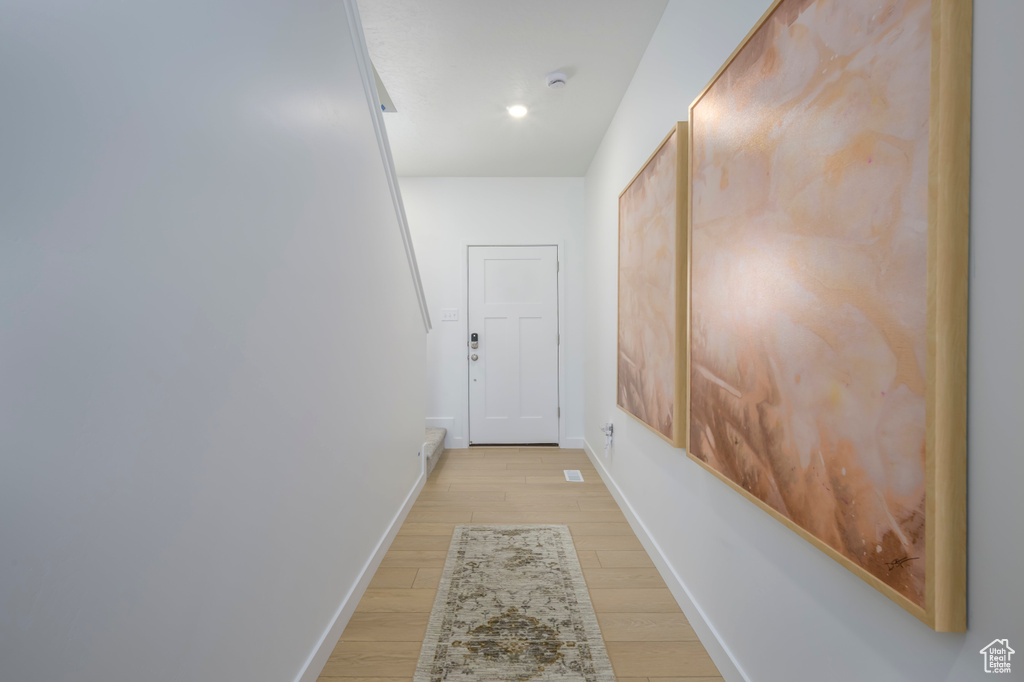 Hallway with baseboards and light wood finished floors