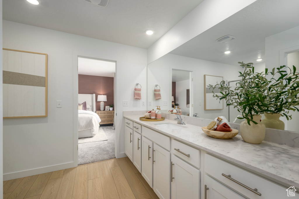 Bathroom with recessed lighting, ensuite bath, vanity, and wood finished floors
