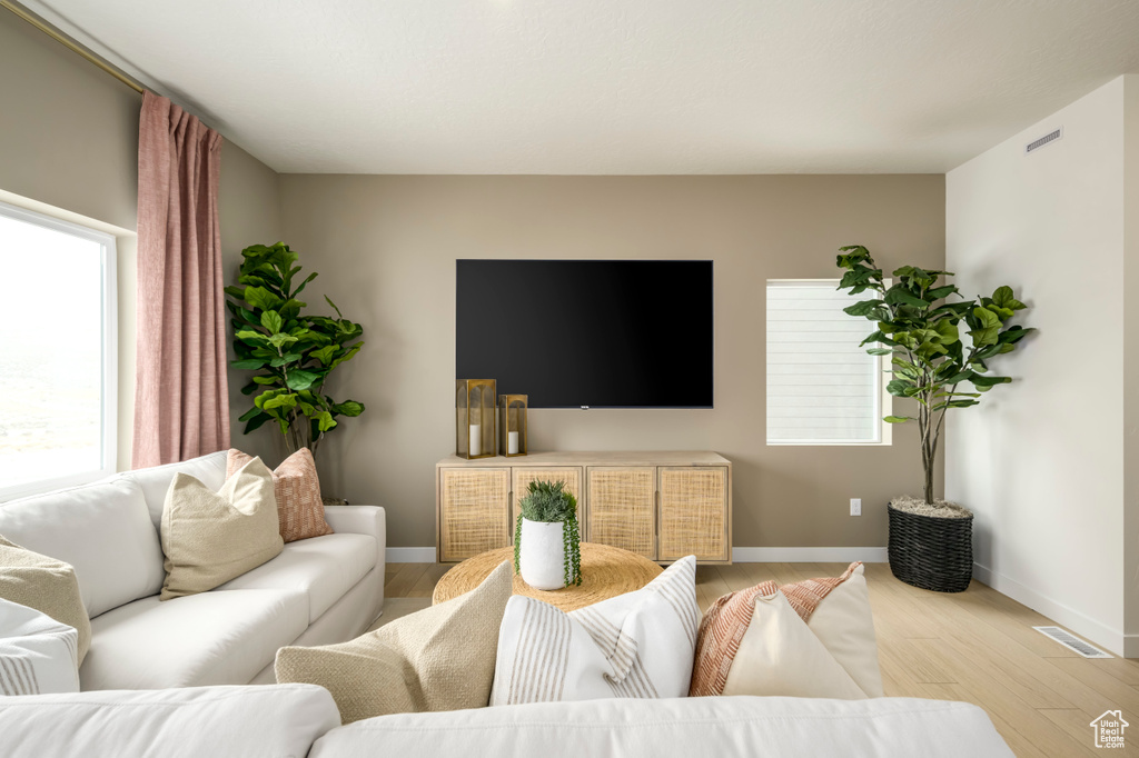 Living room with visible vents, light wood-type flooring, and baseboards