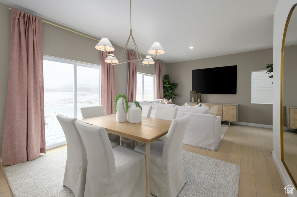 Dining area with a notable chandelier, recessed lighting, light wood-type flooring, and baseboards
