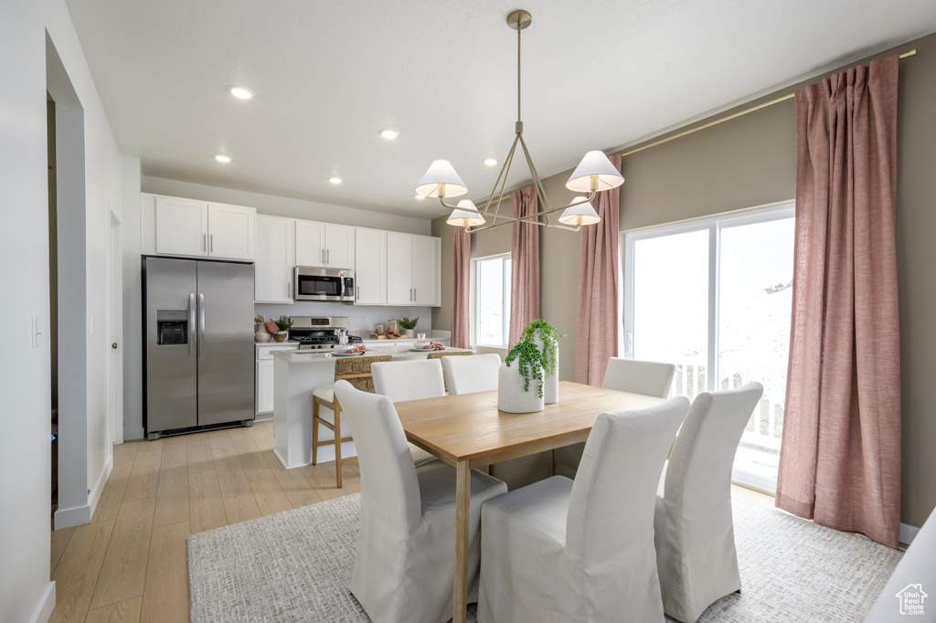 Dining area with light wood-style flooring and recessed lighting