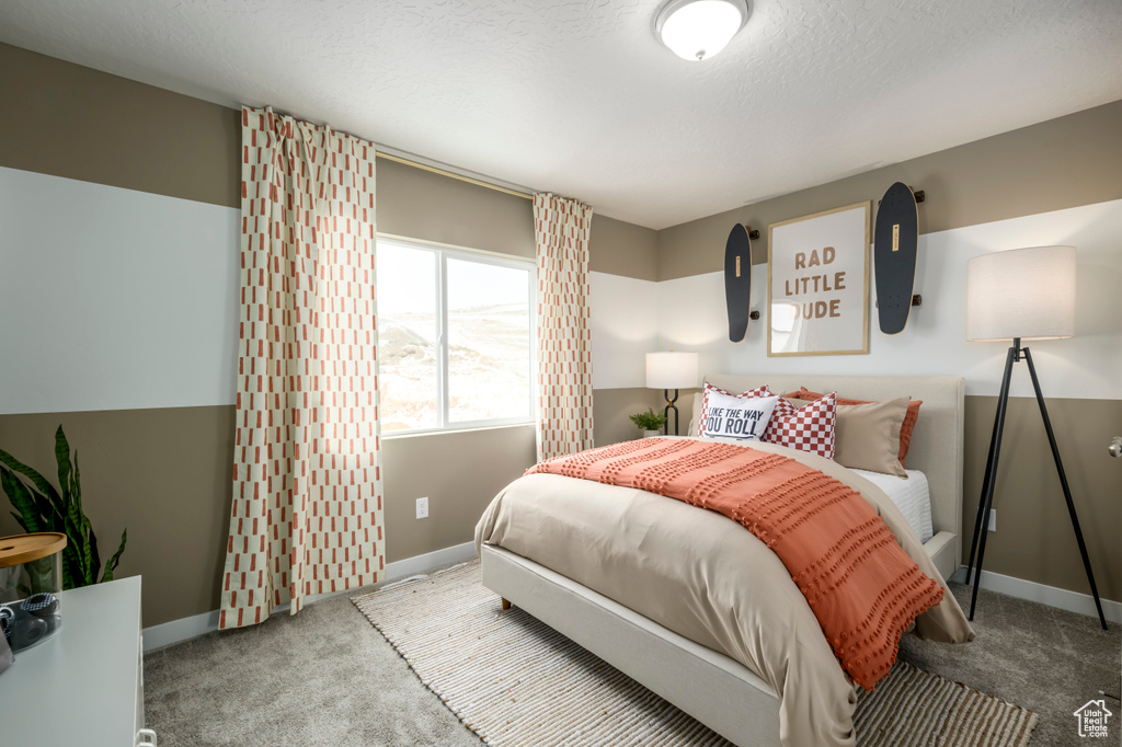 Bedroom with carpet flooring, a textured ceiling, and baseboards