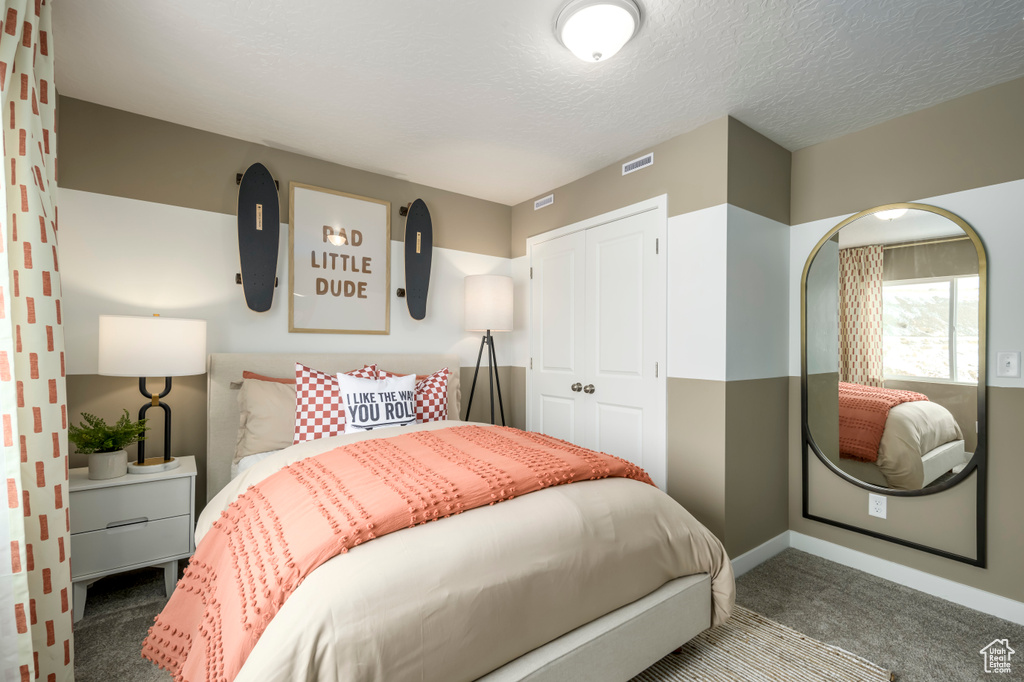 Bedroom featuring visible vents, carpet, a closet, and a textured ceiling