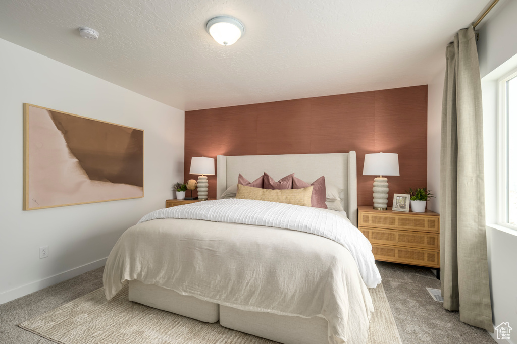 Carpeted bedroom with baseboards and a textured ceiling