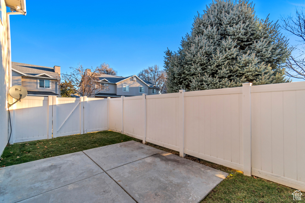 View of patio with a fenced backyard and a gate