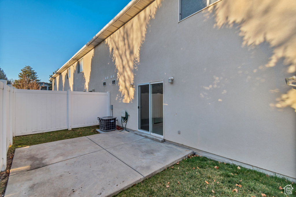 Back of property featuring fence private yard, a patio area, central AC, and stucco siding