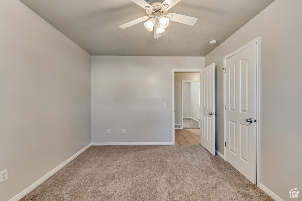 Unfurnished bedroom with ceiling fan, baseboards, and carpet