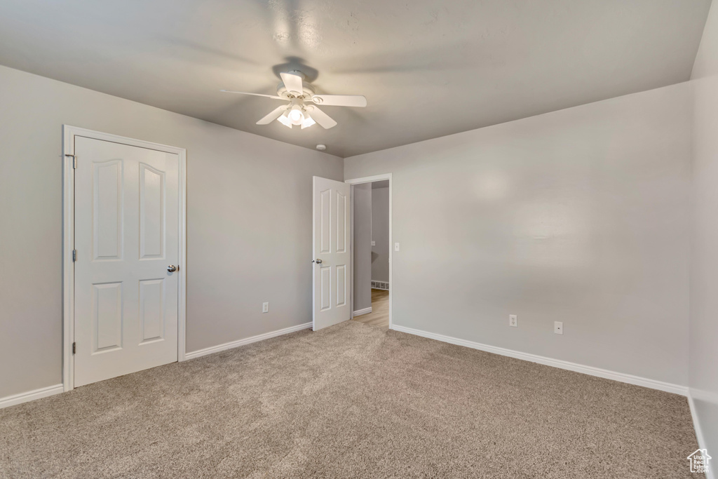 Unfurnished bedroom featuring carpet flooring, a ceiling fan, and baseboards