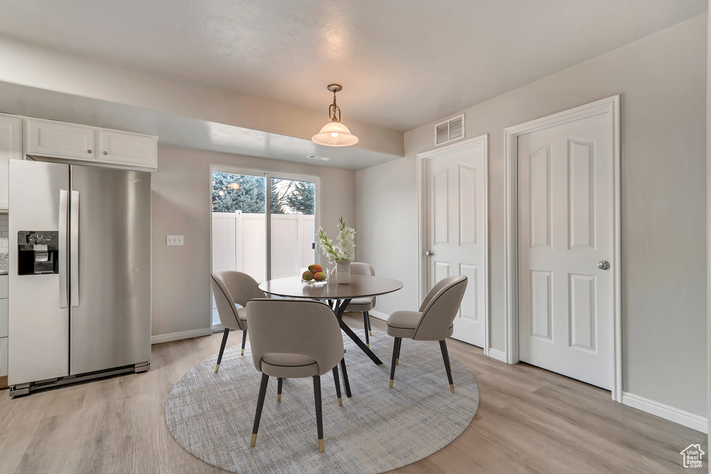 Dining room with visible vents, baseboards, and light wood-style floors