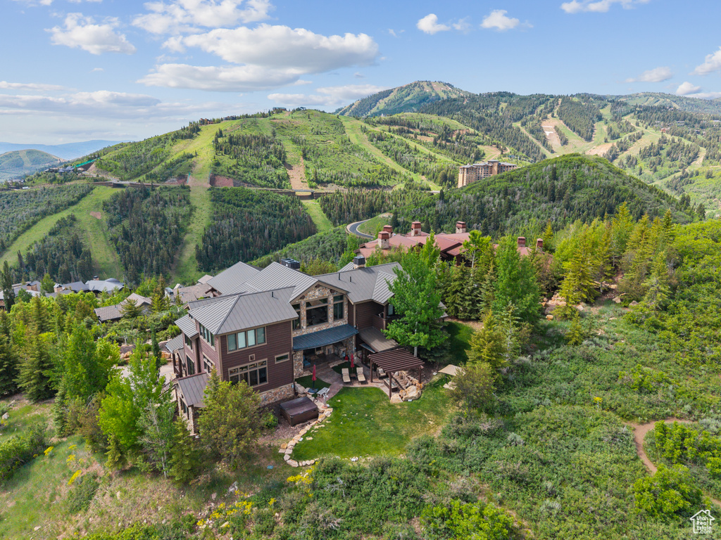 Aerial view of property and surrounding area featuring a mountainous background