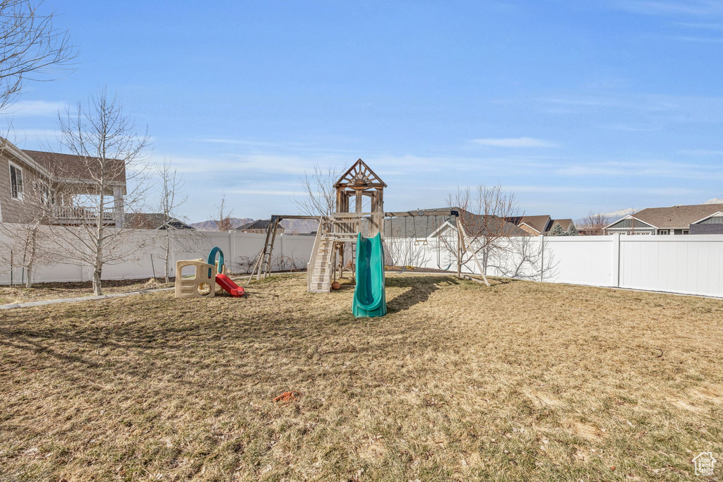 View of playground featuring a yard and a fenced backyard