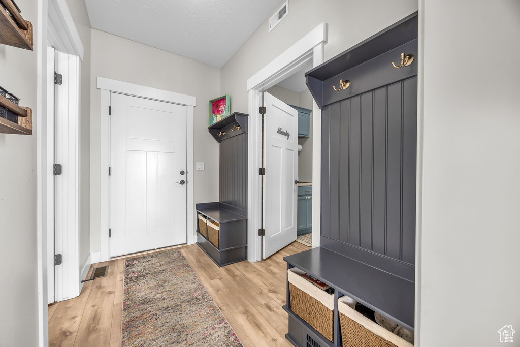 Mudroom with light wood-style flooring and visible vents